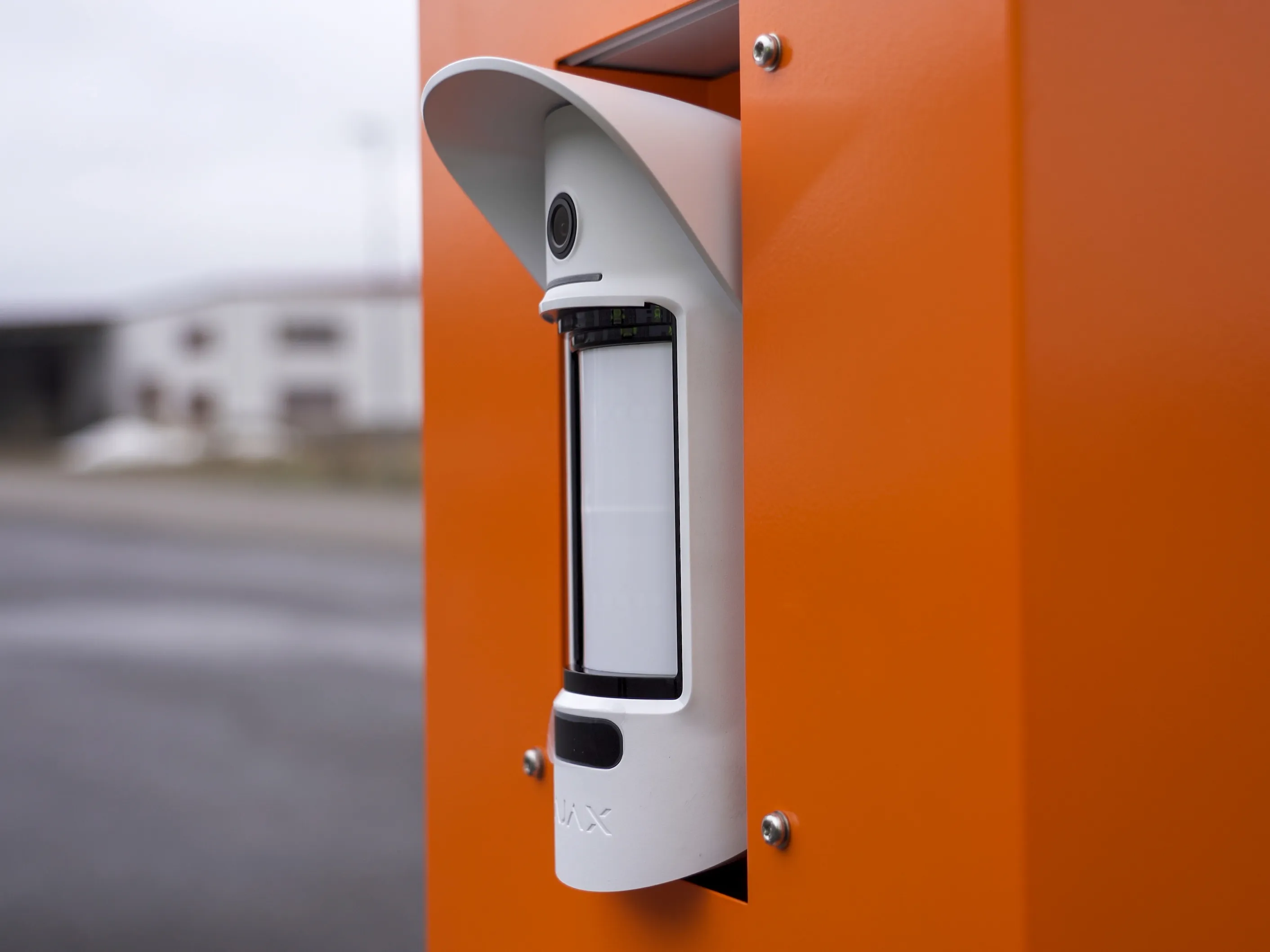 Närbild på säkerhetsboxens kamera- och högtalarmodul på det orange höljet